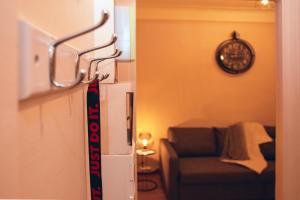 a living room with a couch and a clock on the wall at Cozy stash between Paris & Disney in Neuilly-Plaisance +7 photos