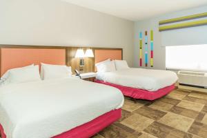 a hotel room with two beds and a window at Hampton Inn Garden City in Garden City