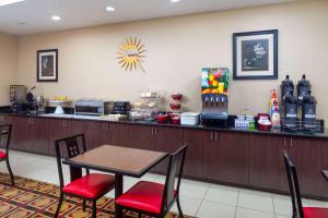 a restaurant with a bar with a table and chairs at La Quinta by Wyndham Macon West in Macon