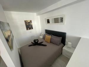 ein Schlafzimmer mit einem Bett mit einem schwarzen Schal darauf in der Unterkunft La Casita de Niagara in San Miguel de Abona + 6 Fotos