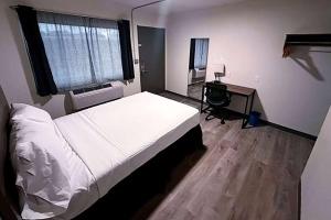 Postel nebo postele na pokoji v ubytování Studio City Suites, a Travelodge by Wyndham