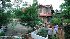 un groupe de personnes debout devant une maison dans l'établissement Green Nestle Heritage Homestay, à Kaduturutti