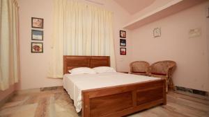 une chambre avec un lit et deux chaises et une fenêtre dans l'établissement Green Nestle Heritage Homestay, à Kaduturutti