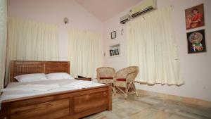 une chambre avec un lit, une table et des chaises dans l'établissement Green Nestle Heritage Homestay, à Kaduturutti 4 autres photos