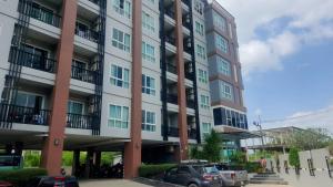 Un gran edificio con coches aparcados delante. en spacious and modern Apartment in Ao Nang, en Ban Khlong Haeng