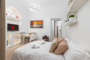una camera da letto bianca con un letto e una scrivania di Wonderful Brera Suite near Moscova M2 a Milano