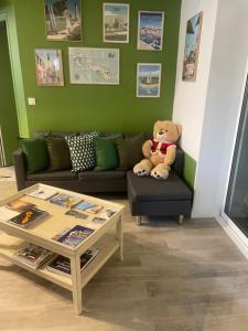 a teddy bear sitting on a couch in a living room at Le Petit Bois in Sainte-Marie-de-Ré
