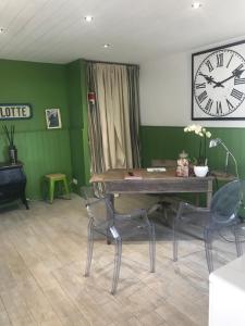 a room with a table and chairs and a clock at Le Petit Bois in Sainte-Marie-de-Ré