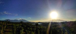 a sun rising over a mountain with a road at Villa Murah BOEKIT 3G dgn View 3 Gunung & Sunrise in Cikidang +5 photos