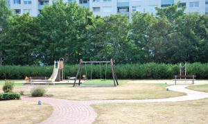 un parco con parco giochi con scivoli e panchine di Haus Trafalgar App 255 a Cuxhaven