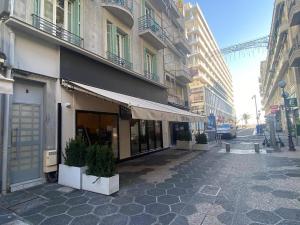 un bâtiment dans une rue avec des plantes en pot sur le trottoir dans l'établissement Cosy Studio Promenade, à Nice