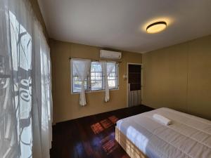 a bedroom with a bed and two windows at Demi house in Nong Khai
