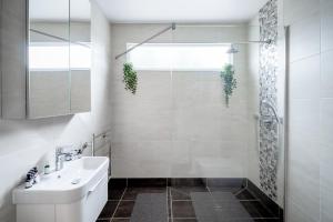 a white bathroom with a sink and a shower at Luxury three bedroom serviced apartment - Springfield in Claygate +23 photos