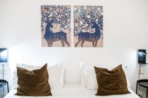 1 cama con 2 pinturas en la pared y 2 almohadas en Giano Host - Indoratori, en Génova