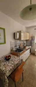 a kitchen with a table with a bowl of fruit on it at Residence Paula in Jadranovo