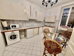 - une cuisine avec des appareils blancs, une table et des chaises dans l'établissement Large 2-bedroom apartment large living room with parking near train station and downtown, à Grenoble