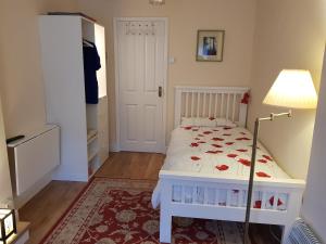 a bedroom with a white bed and a lamp at Casa Caversham in Caversham