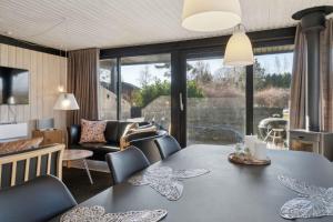 a living room with a table with butterfly chairs at Cottage Near Idyllic & Peaceful Sandy Beach in Rønne