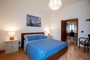 a bedroom with a blue bed and a dining room at Wonderful in the historic center La Scoletta in Bracciano
