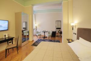 1 dormitorio con 1 cama y sala de estar en Grand Hotel Nizza Et Suisse, en Montecatini Terme