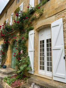 an old building with white doors and flowers on it at Maison Honorine in Saint-Geniès +6 photos