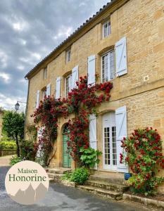 un bâtiment avec des fleurs sur le côté dans l'établissement Maison Honorine, à Saint-Geniès