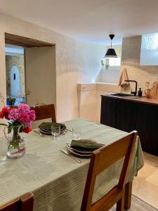 une cuisine avec une table avec un vase de fleurs dessus dans l'établissement Maison Honorine, à Saint-Geniès