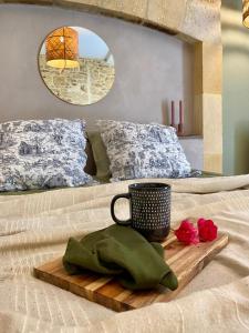 - un plateau avec une tasse et des roses sur le lit dans l'établissement Maison Honorine, à Saint-Geniès