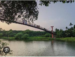 people walking across a bridge over a river at Sallyies Homestay Gust House in Kottayam
