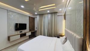 a hotel room with a bed and a tv at Leisure Homes in Lucknow
