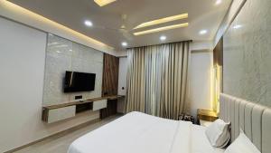 a bedroom with a bed and a flat screen tv at Leisure Homes in Lucknow