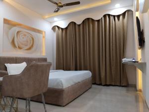 a hotel room with a bed and a curtain at Leisure Homes in Lucknow