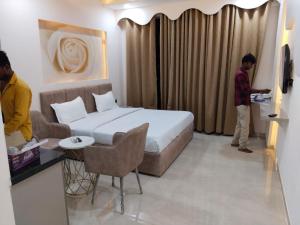 a hotel room with a bed and a couple of people in it at Leisure Homes in Lucknow +15 photos