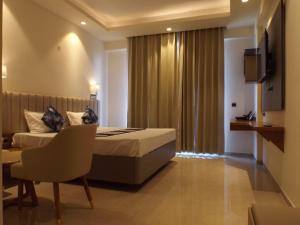 a hotel room with a bed and a chair and a window at Leisure Homes in Lucknow