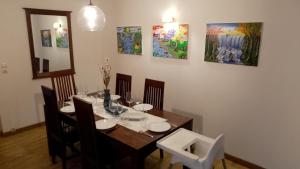 a dining room with a table and chairs and paintings at Loft en duplex avec vue sur plage et chenal in Dieppe