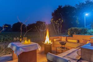 a fire pit with a couch and a table at ELIVAAS Hari Bagh 4 BHK Villa with Gaming Zone & Art Nook in Jaipur