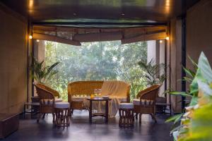 a patio with a table and chairs and a window at ELIVAAS Hari Bagh 4 BHK Villa with Gaming Zone & Art Nook in Jaipur +129 photos