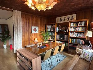 a living room with a wooden table and bookshelves at Hong Principal House in Daegu