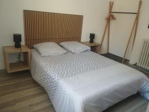 a bedroom with a large white bed with two pillows at les oliviers in Carpentras