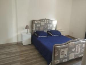 a bedroom with a bed with a blue comforter at les oliviers in Carpentras +5 photos