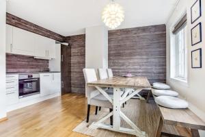 a kitchen and dining room with a wooden table and chairs at Mountain apartment Røldal alpine center in Håra +15 photos