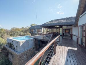 an outdoor deck with a swimming pool on a house at Des'lgodini Lodge - PRM078 in Bela-Bela