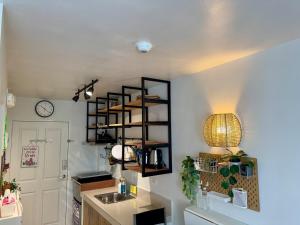 a kitchen with a sink and a clock on a wall at Unit 26 SeaView Studio in Dumaguete