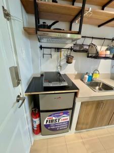 a small kitchen with a stove and a sink at Unit 26 SeaView Studio in Dumaguete