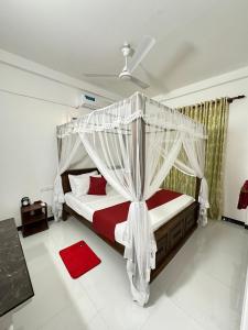 a bedroom with a canopy bed and a red rug at Seagate Villa in Bentota