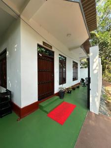 a house with a green floor and a red rug at Seagate Villa in Bentota