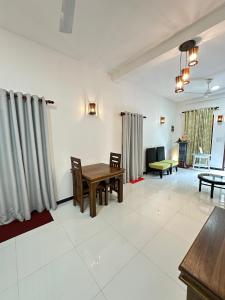 a living room with a wooden table and chairs at Seagate Villa in Bentota
