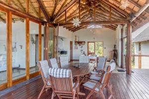 a dining room with a wooden table and chairs at Des'lgodini Lodge - PRM078 in Bela-Bela