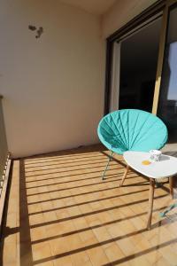 a room with a table and a blue umbrella at Sublime Appartement avec Parking Privé à Ajaccio in Ajaccio