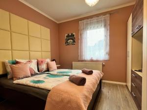 a bedroom with a bed with two towels on it at Dorina Wellness Apartman in Siófok